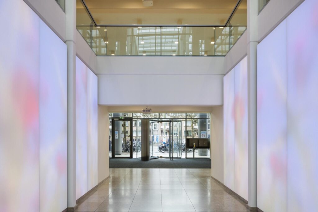 Entrance hall of an office building on Mr. Treublaan with glass doors and illuminated wall panels.